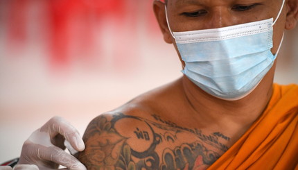 Буддийский монах получает дозу вакцины 